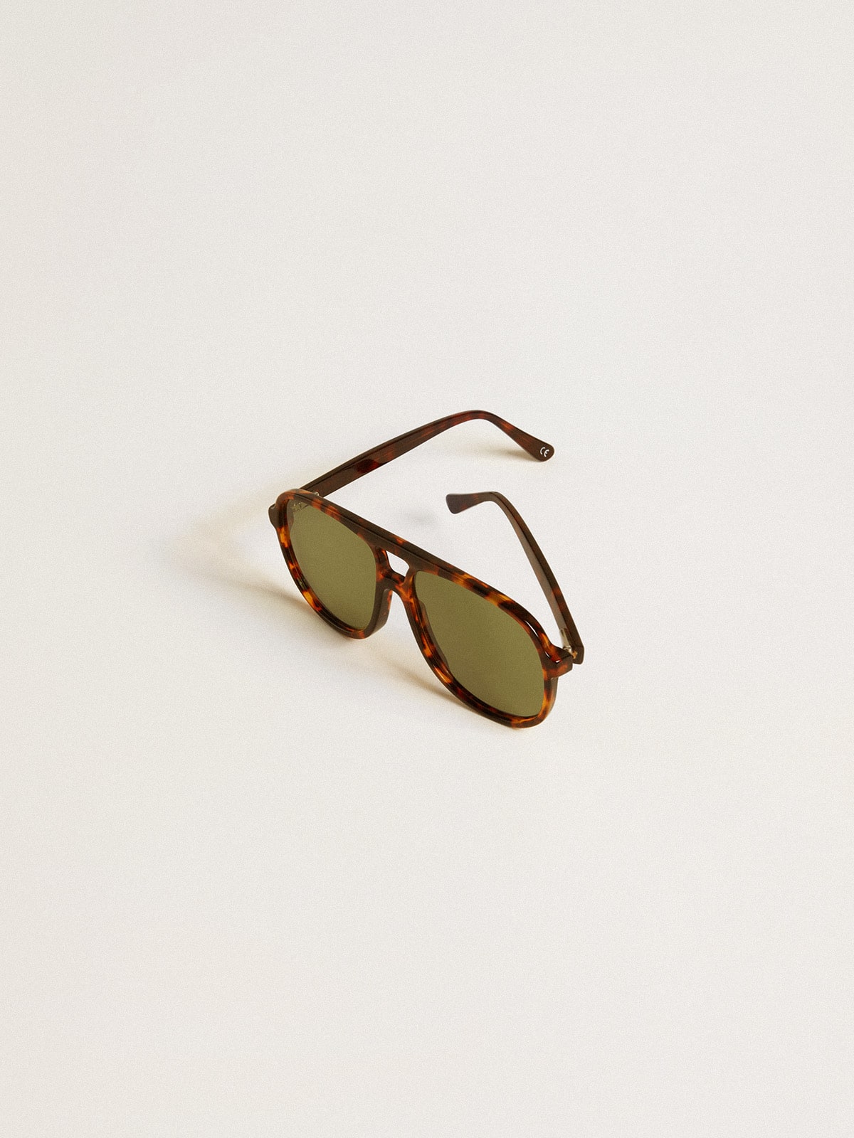 Aviator style sunglasses with tortoiseshell frame and green lenses