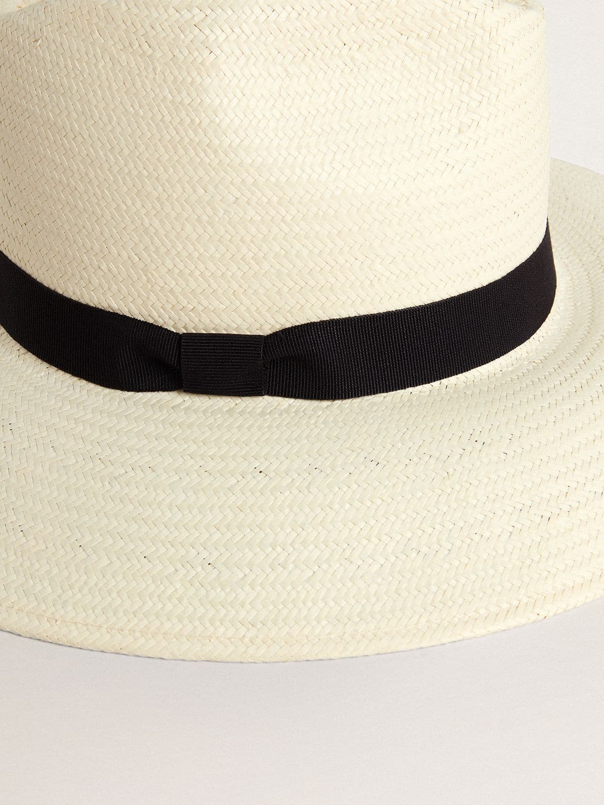 Golden fedora hat in white straw with black ribbon and marine print under the brim