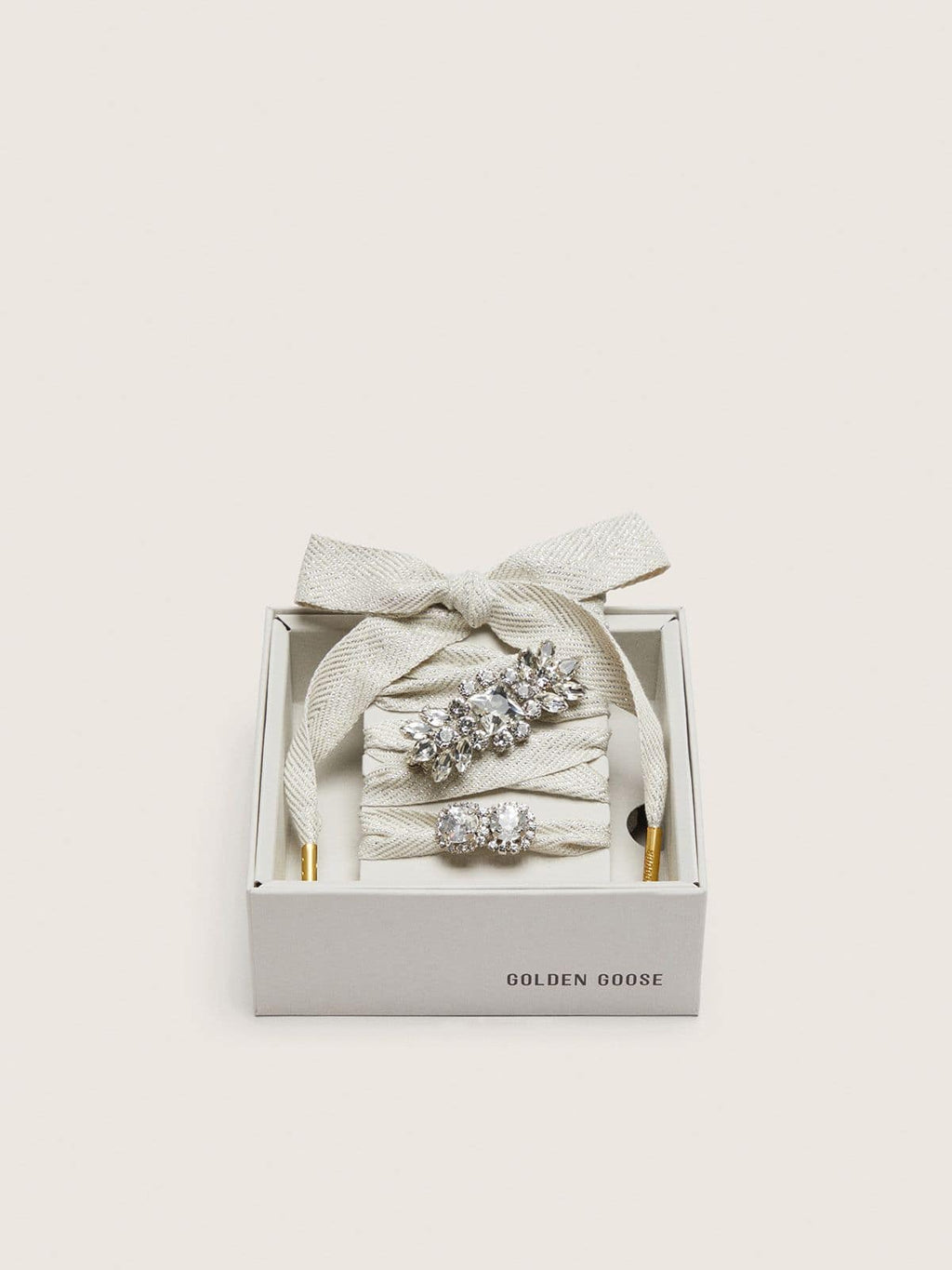 Skin "Sparkling" cream and silver herringbone laces with two appliqué charms