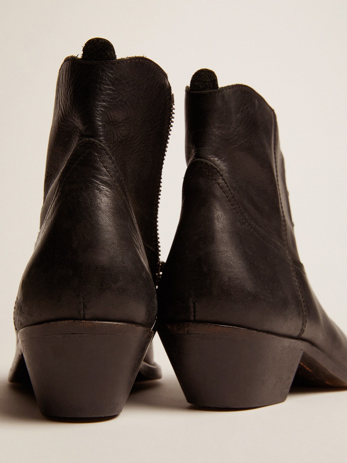 Young ankle boots in black leather with sand-colored embroidery